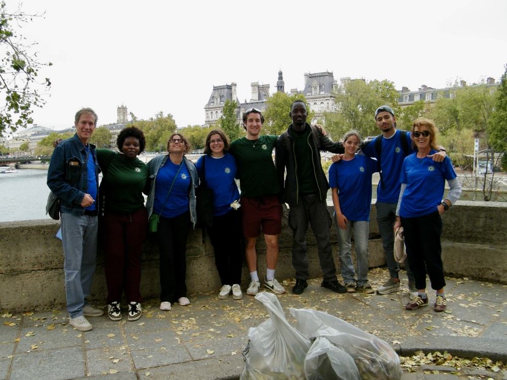 Volunteers on the banks of the Seine in front of the Hôtel de Ville, with bags of collected litter