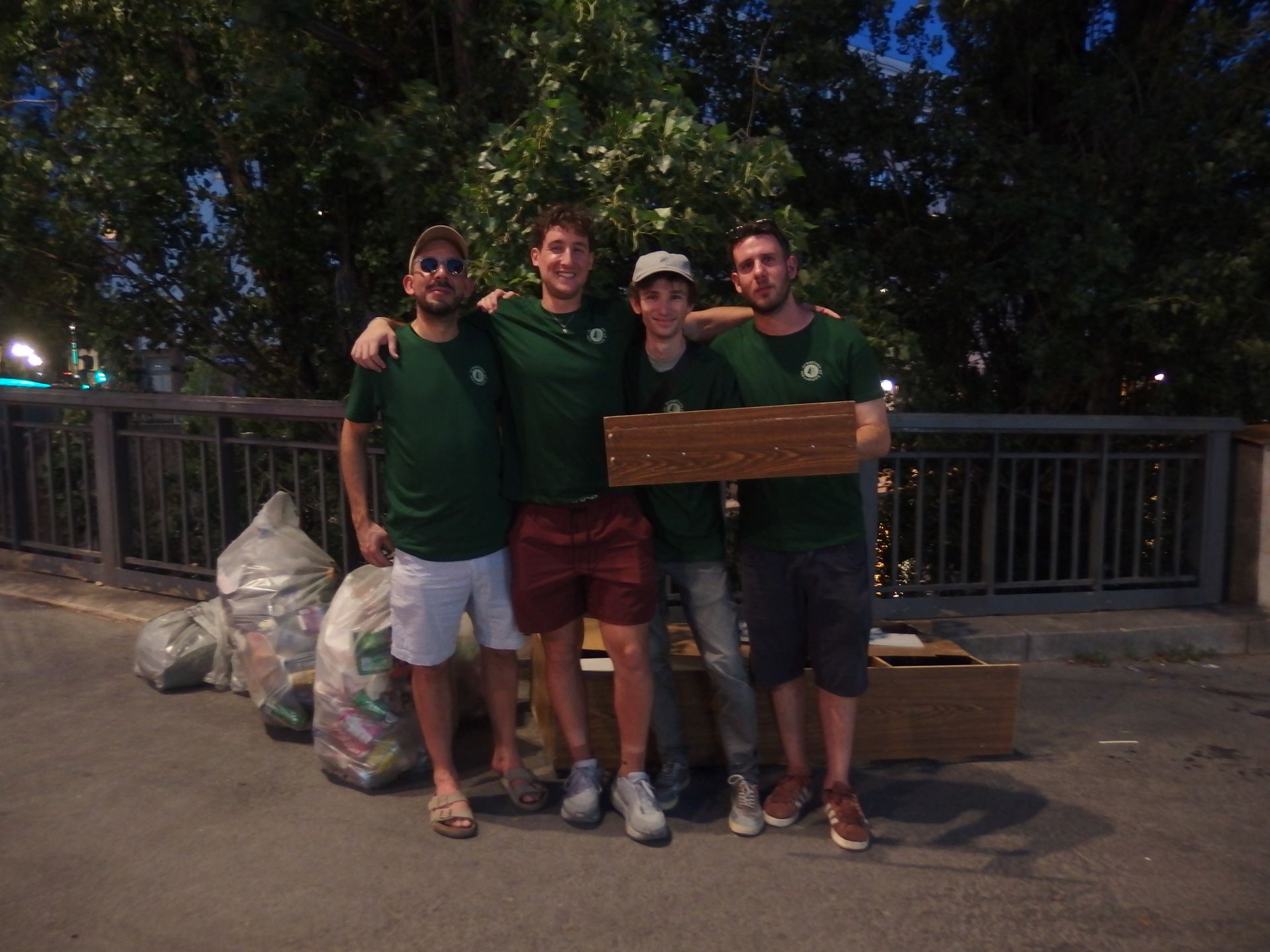 Four Creatives of Tomorrow volunteers on a bridge over the Canal Saint-Martin after a cleanup